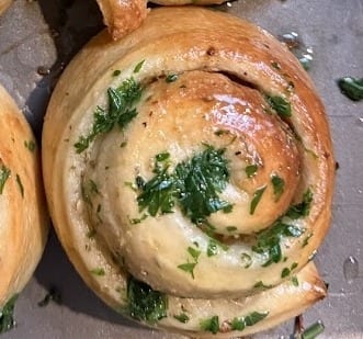 Golden fluffy garlic rolls brushed with herb butter